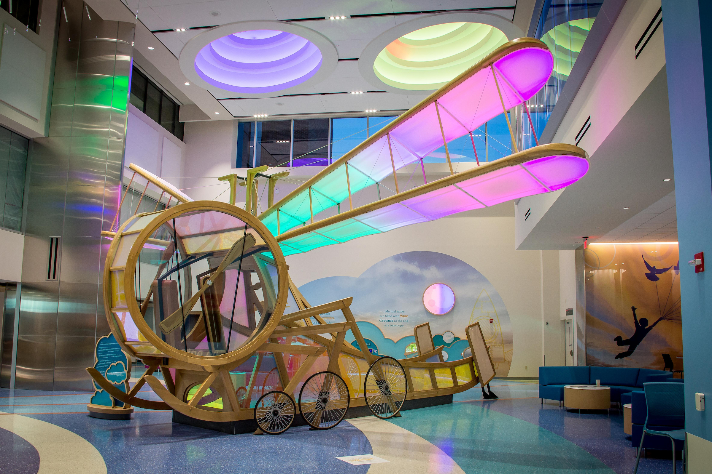 Interactive art display any play area for kids the looks like a dragonfly with wings of a plane.