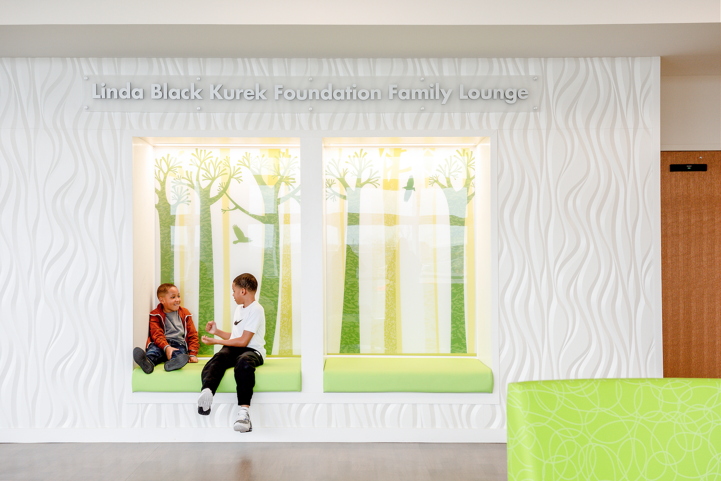 Two boys sitting in bright kid-friendly lobby area waiting for appointment at Dayton Childern's