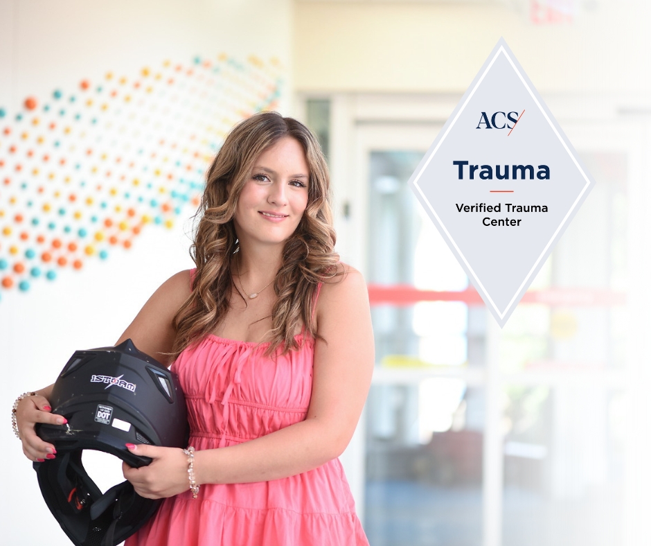 Teen girl holding helmet after outside of emergency department with a Level 1 Trauma Center logo