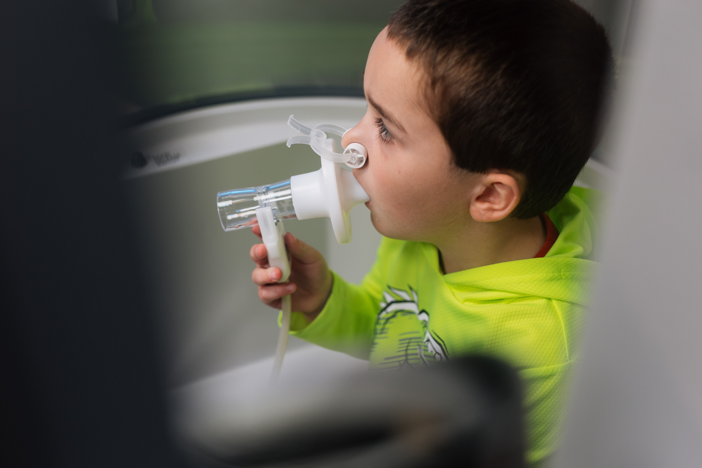 young boy receiving a breathing treatment in a pediatric emergency exam room