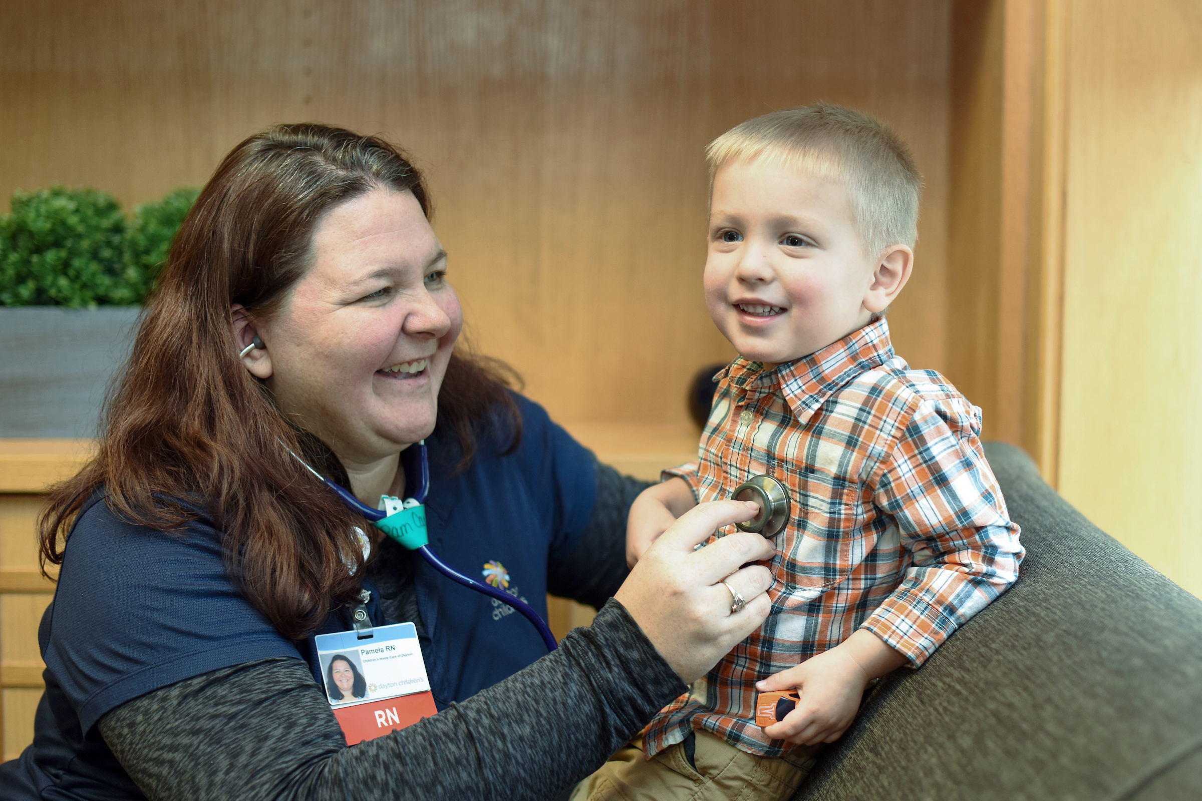 nurse listening to child's heart during a home care visit.