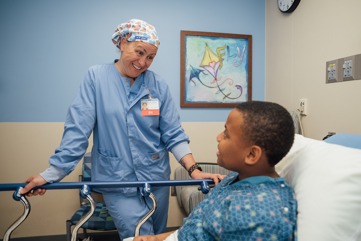 Female nurse preparing a teen boy for surgery.