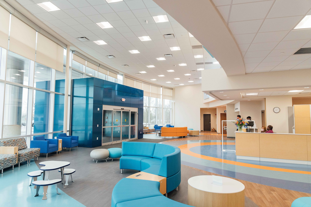 Bright, colorful and modern lobby of outpatient care cetner with seating for adults and kids.