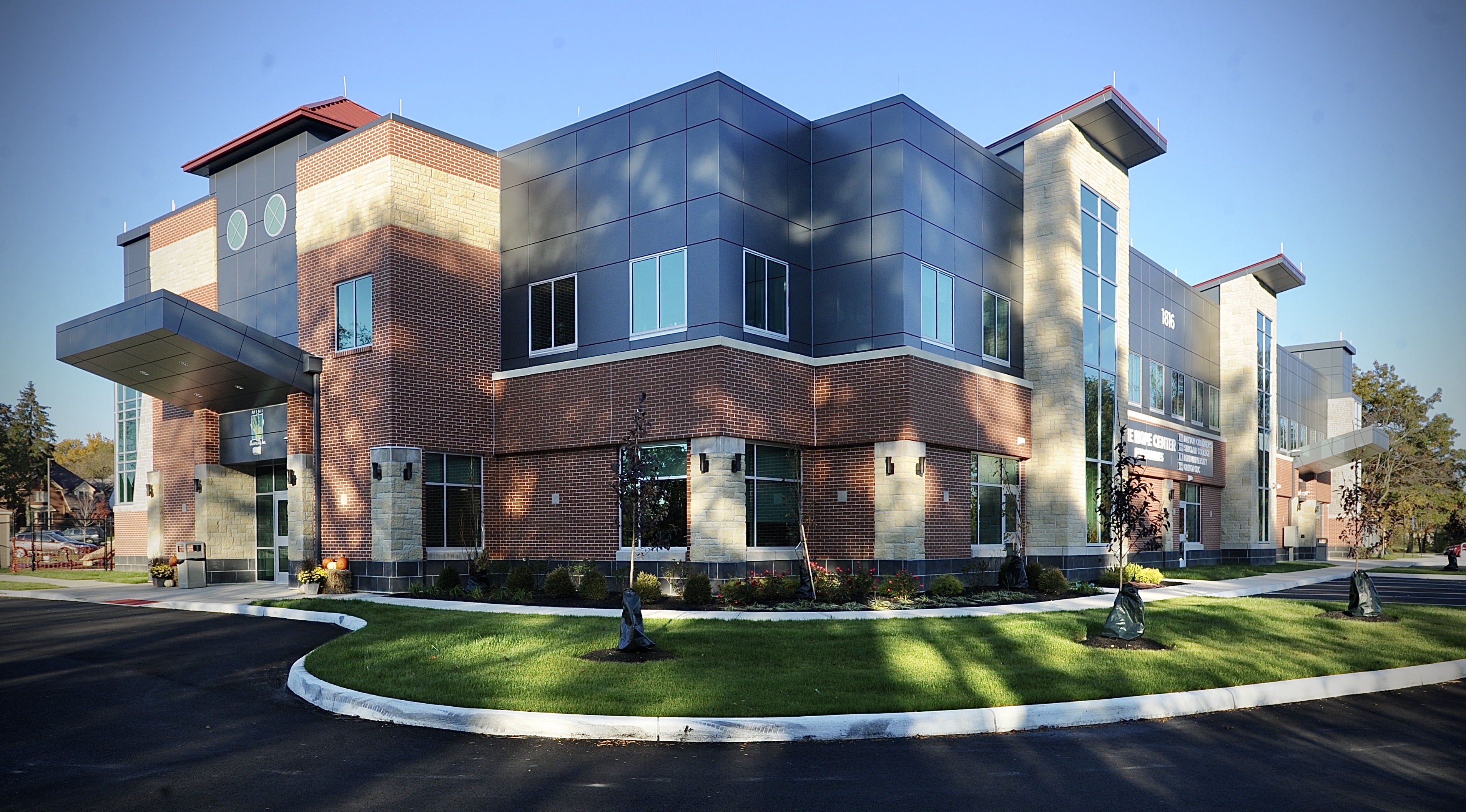 exterior view of blue and brick two story building.