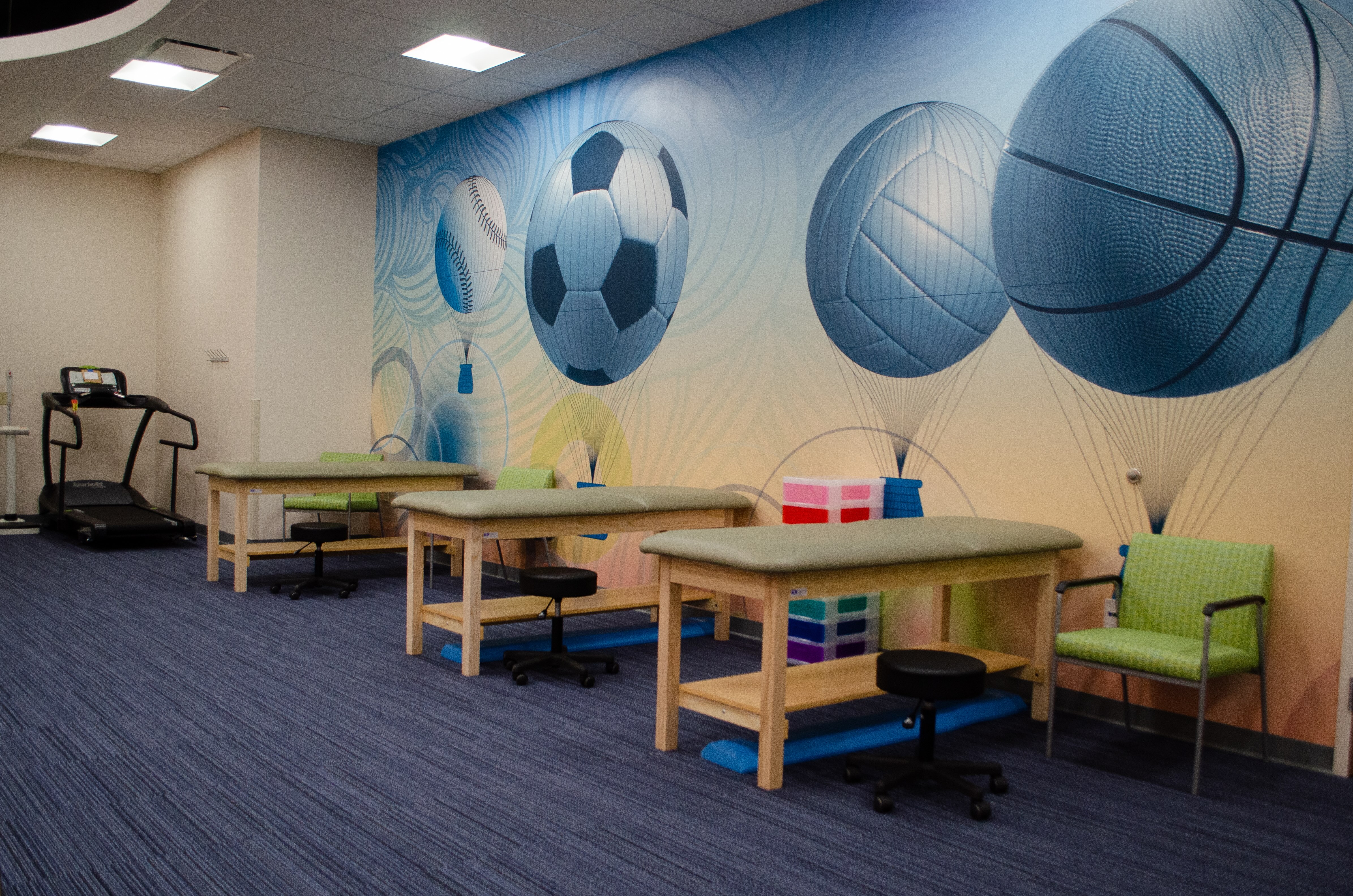 Colorful room with various play activities for pediatric rehabilitation therapies.